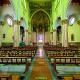 Varchiamo l�ingresso e ci ritroviamo davanti a tre navate scandite da nove colonne sui cui capitelli sono impostati archi a pieno centro. Lo spazio � un po� buio e la poca luce che filtra dal variopinto rosone trasforma il color oro delle pareti in un verde pallido